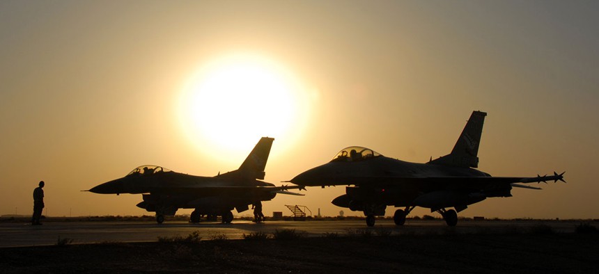 A pair of Air Force F-16 Fighting Falcons sit on the flight line at Balad Air Base in Iraq at sunset in 2007.