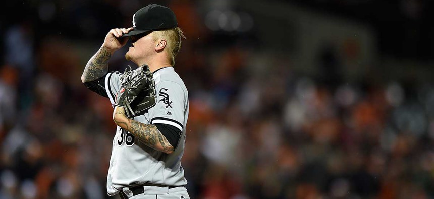 Chicago White Sox pitcher Mat Latos hides his face in his hat after giving up home runs in an April game.