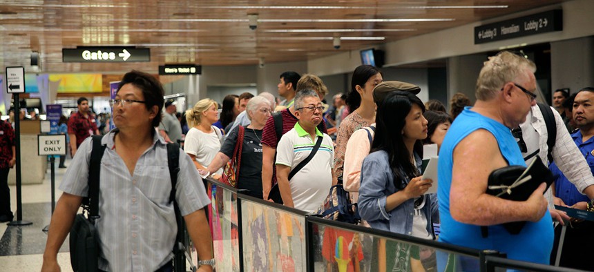Travelers wait in security checkpoint lines at Honolulu International Airport on Thursday.