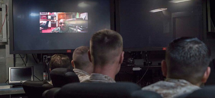 The 18th Sgt. Maj. of the Marine Corps, Ronald Green, speaks to Marines and Sailors attached to the 26th Marine Expeditionary Unit (MEU) in the flag plot conference room during a video teleconference call in February