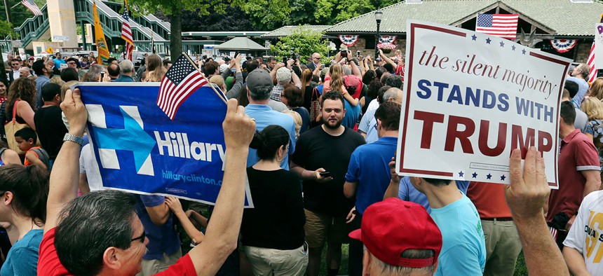 Clinton and Trump supporters hold signs at a Memorial Day parade in Chappaqua, N.Y. 