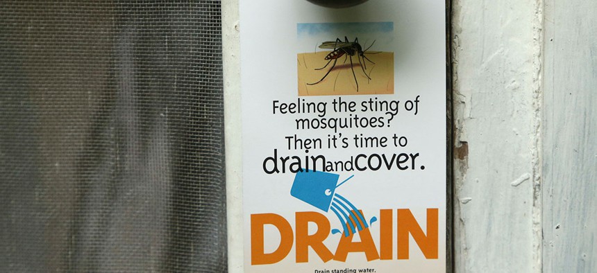 A flyer is left on the doorknob of a home by an inspector from the Miami-Dade County Mosquito Control department on Tuesday in Miami.
