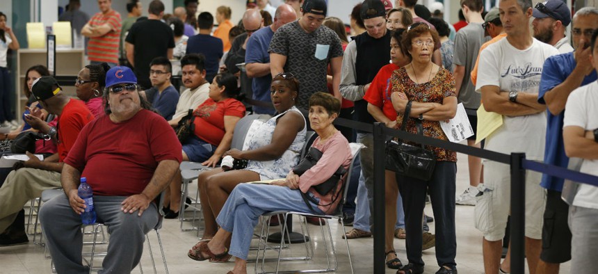 People wait in line at a Nevada Department of Motor Vehicles office in Las Vegas last summer.