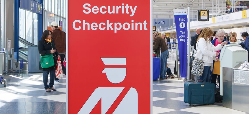 A sign directs travelers toward security checkpoints at O'Hare International Airport in Chicago in April.