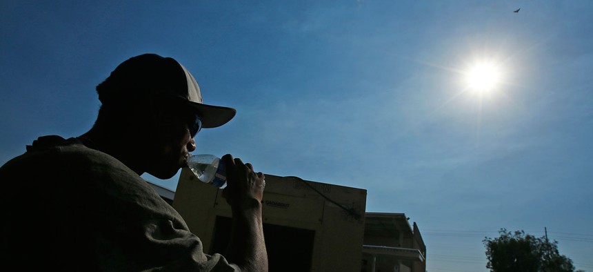 A staffer at the Phoenix Rescue Mission takes a drink of water. Temperatures reached over 115 degrees in Arizona in June.