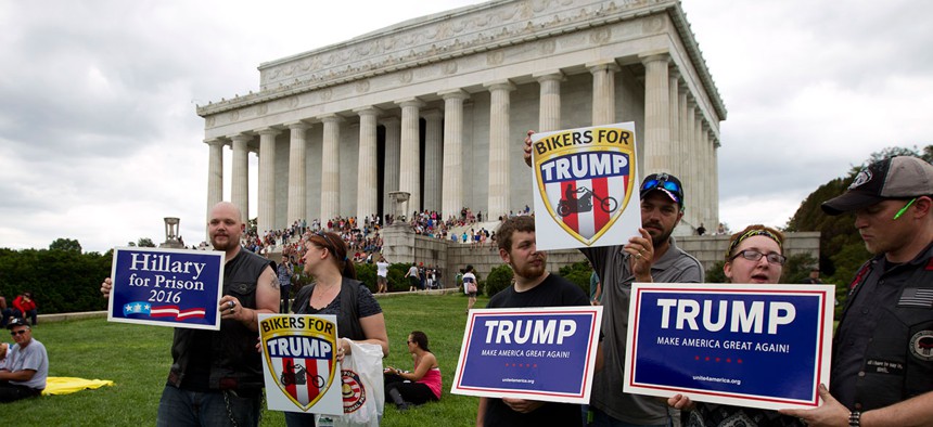 Donald Trump supporters hold up their signs as they wait for the candidate to make an appearance in May.