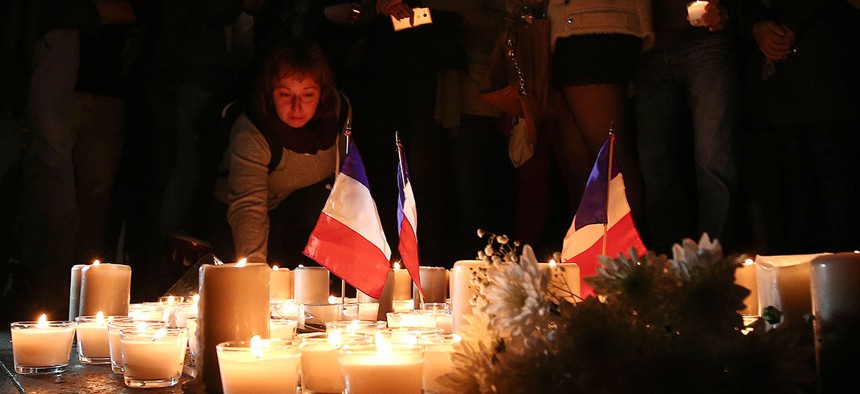 A woman places a candle during a vigil to honor victims of the Bastille Day tragedy in Nice, France, in Sydney, Australia on Friday.