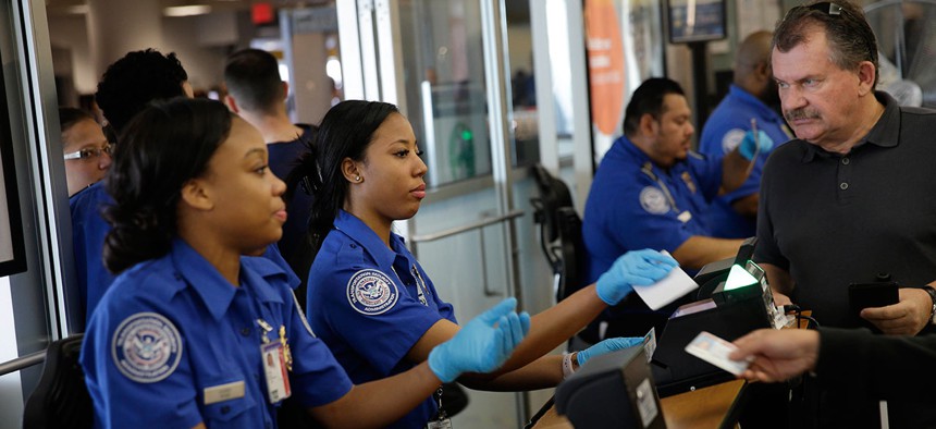 Transportation Security Administration employees check passengers' identifications at a security check point at LaGuardia Airport in May.