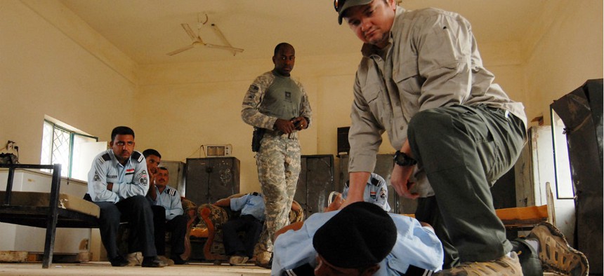 A contractor demonstrates a restraining technique during a training session for the Iraqi police in 2008.
