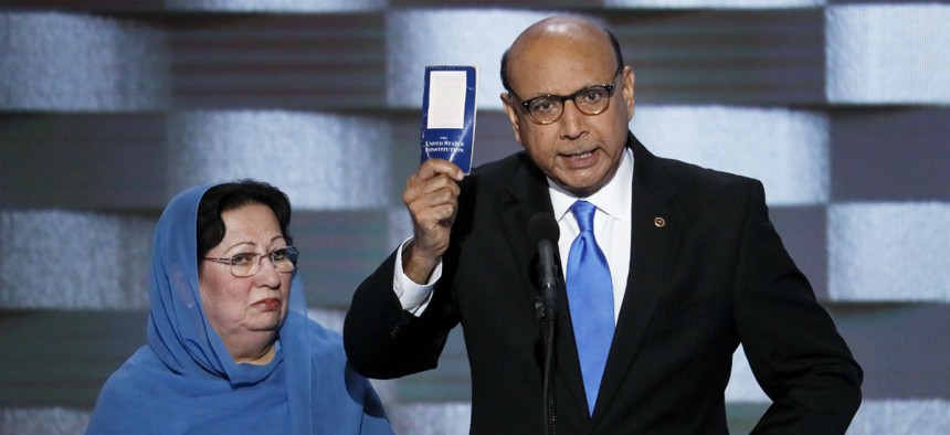 Khizr Khan, father of fallen U.S. Army Capt. Humayun S. M. Khan, holds up a copy of the Constitution as his wife, Ghazala, listens during the Democratic National Convention.