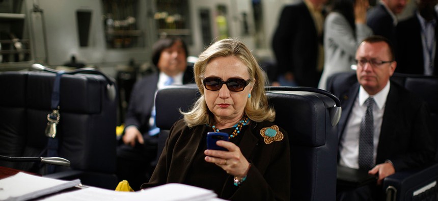 Then-Secretary of State Hillary Rodham Clinton checks her Blackberry from a desk inside a C-17 military plane bound for Tripoli, Libya. 