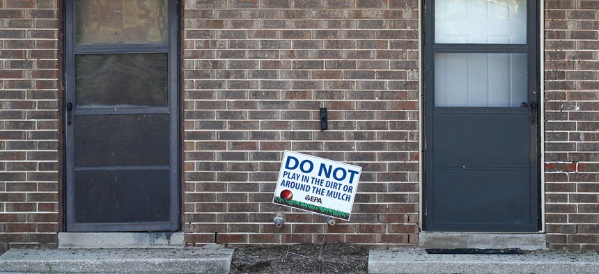 In this Aug. 23, 2016 photo, a sign from the Environmental Protection Agency is posted in front of West Calumet Housing Complex houses at East Chicago, Ind. 