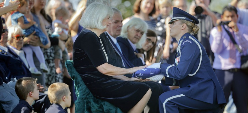 Air Force Capt. Jennifer Lee presents an American flag to Terry Harmon, daughter of World War II pilot Elaine Danforth Harmon, during burial services Wednesday.