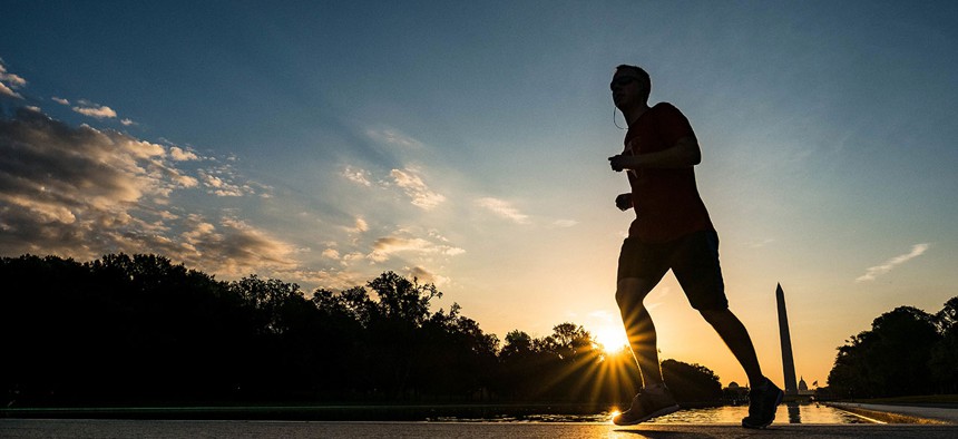 A runner passes the reflecting pool on the National Mall in Washington in August during an excessive heat watch for D.C.