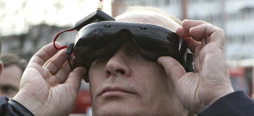 Russian Prime Minister Vladimir Putin tests goggles with an electronic connection that allows him to see the view from an unmanned drone aircraft, during an exhibition of equipment displayed at Russia's Civil Defense Academy in Moscow's Khimki surburbs.