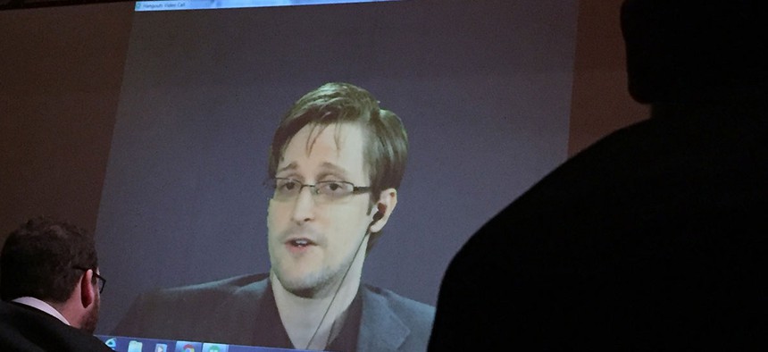 Former National Security Agency contractor Edward Snowden, center speaks via video conference to people in the Johns Hopkins University auditorium, in Baltimore in February.