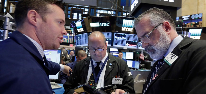 Specialist Frank Masiello, left, works with traders Jeffrey Vazques, center, and Kenneth Polcari on the floor of the New York Stock Exchange in October.