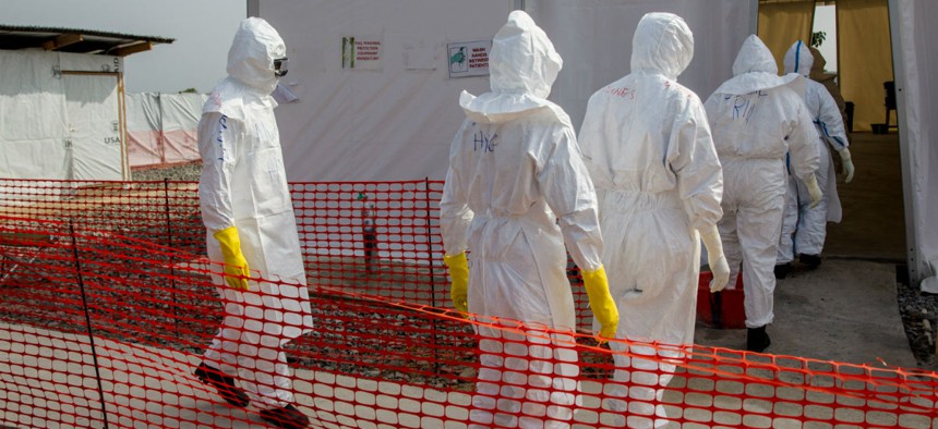 Nurses enter an Ebola treatment unit in Liberia. The facility is operated by the International Organization for Migration in partnership with Liberia's Ministry of Health and Social Welfare and supported by USAID's Office of U.S Foreign Disaster.