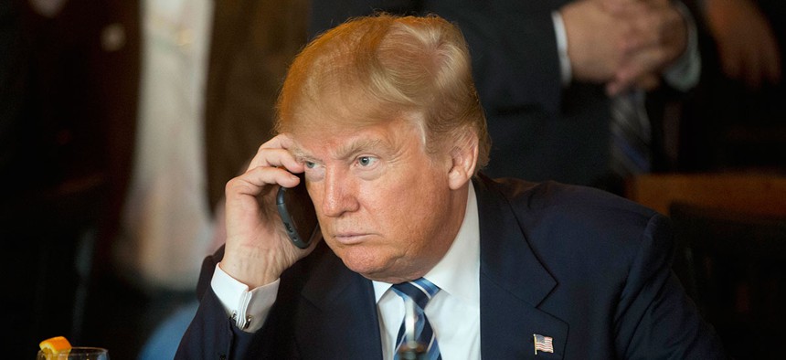 Trump listens to his mobile phone in February.