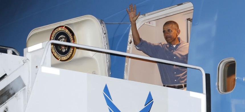 Obama waves as he arrives on Air Force One for his annual family vacation in Hawaii. Trump has targeted a contract to modernize Air Force One. 