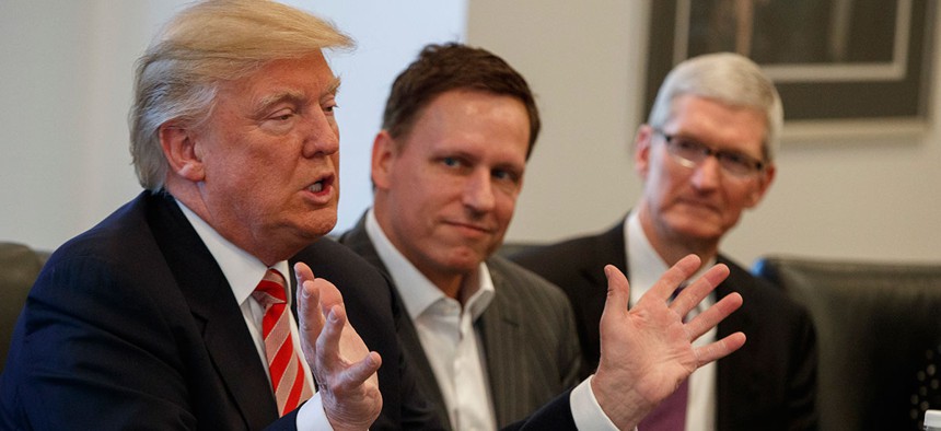 Apple CEO Tim Cook, right, and PayPal founder Peter Thiel, center, listen as President-elect Donald Trump speaks last week.