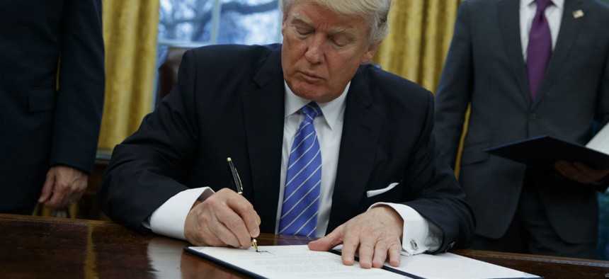 President Trump signs an executive order on Monday. 