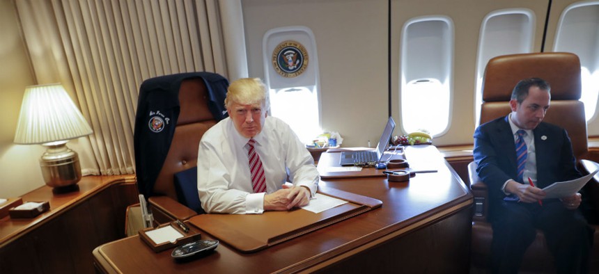 President Donald Trump, with his Chief of Staff Reince Priebus, sits at his desk on Air Force One on Thursday.
