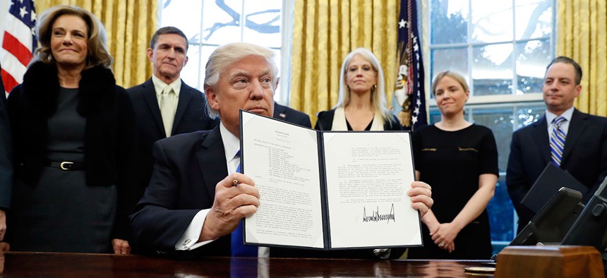 President Donald Trump holds up a signed National Security Presidential Memorandum in the Oval Office on Saturday.
