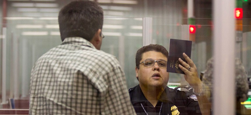 A Customs and Border Protection officer checks a passport inside immigration control at McCarran International Airport in 2011.