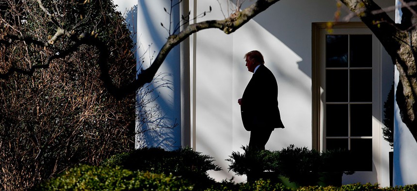 President Donald Trump walks near the White House in February.
