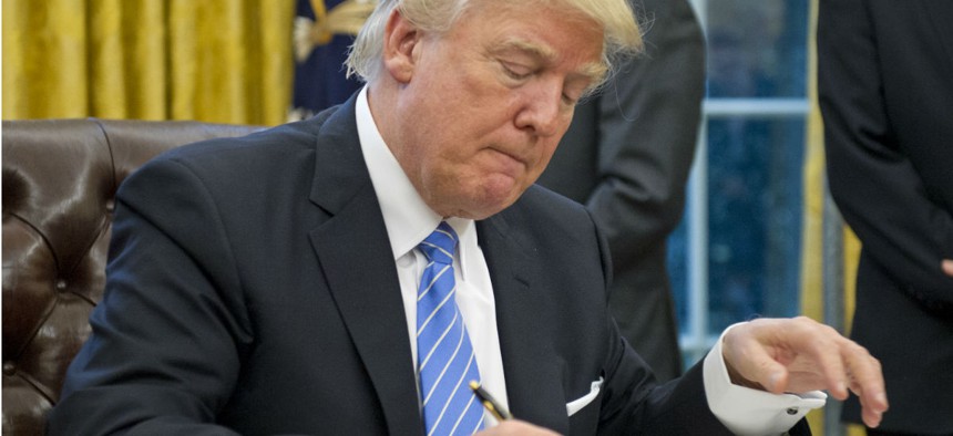 President Trump signs executive orders in January, including the hiring freeze. 
