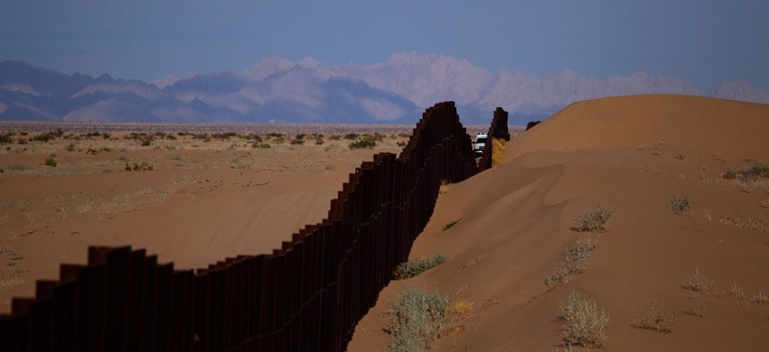 A CBP vehicle drives along the U.S.-Mexico border fence near Yuma, Arizona in 2010.