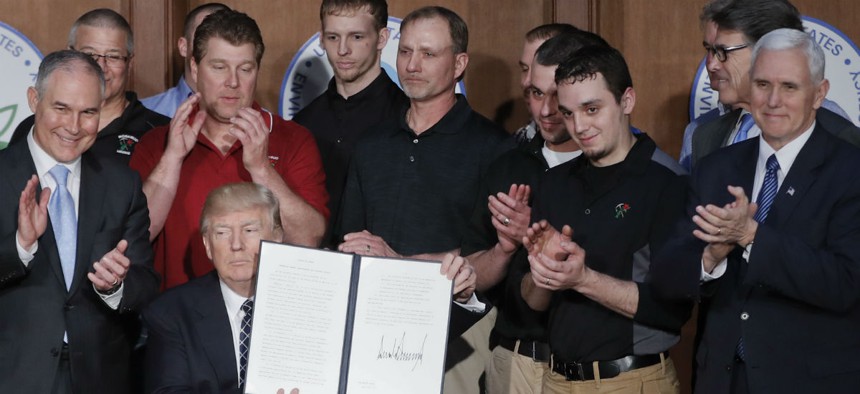 Trump signs the executive order at the EPA. 