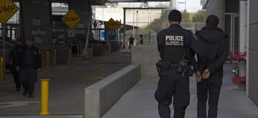 A Customs and Border Protection officer escorts a detainee to a processing area in March 2016.