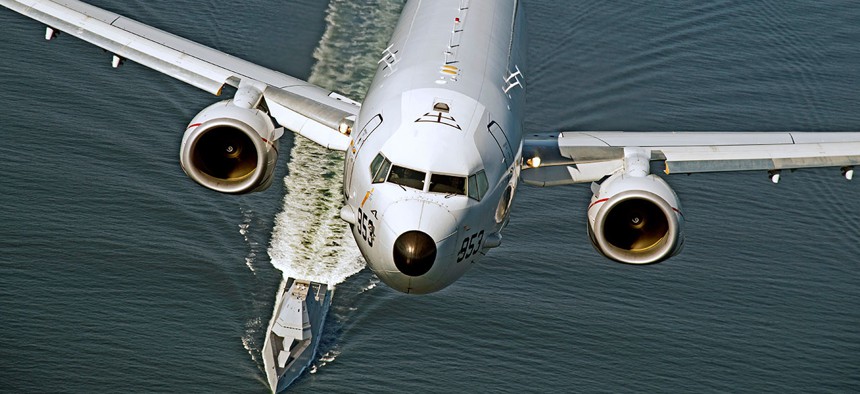 A P-8A Poseidon overflies the U.S. Navy's DDG 1000 destroyer in October 2016. The subhunting plane has been approved for export to New Zealand.