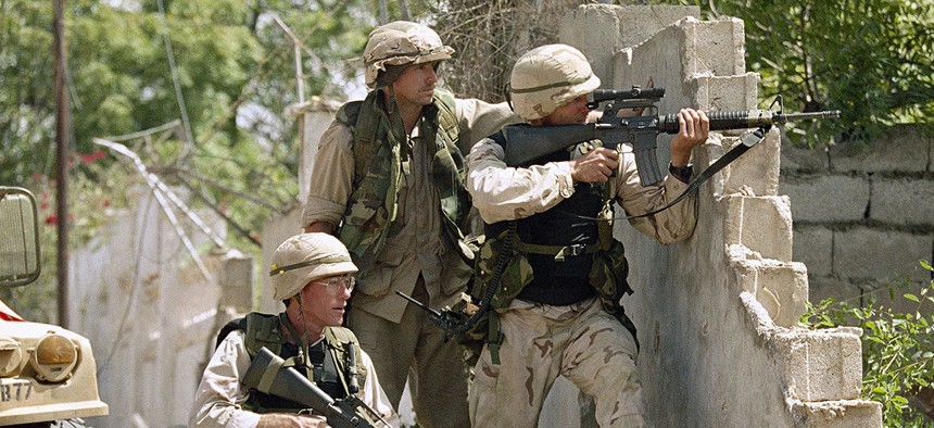 United States soldiers return fire at snipers from behind a wall just outside the compound of Somali warlord Mohamed Farrah Aidid in Mogadishu in 1993.