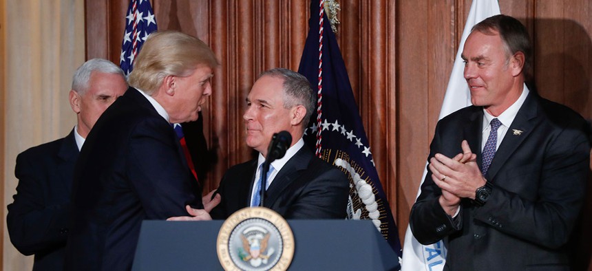 President Donald Trump shakes hands with Environmental Protection Agency Administrator Scott Pruitt, flanked by Vice President Mike Pence and Interior Secretary Ryan Zinke in March.