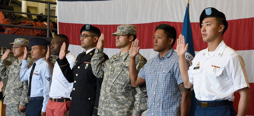 Service members recite the oath of allegiance during a naturalization ceremony conducted in the hanger bay on board USS Somerset in Seattle in 2016.
