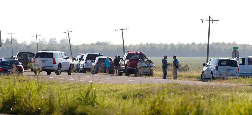 Emergency personnel stand along U.S. Highway 82 following the plane crash on July 10, 2017.