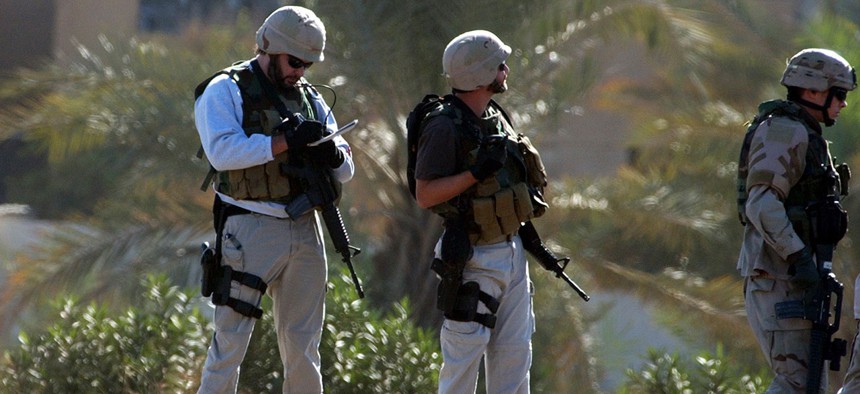 Two U.S. private security contractors investigate a site in Iraq in 2004.