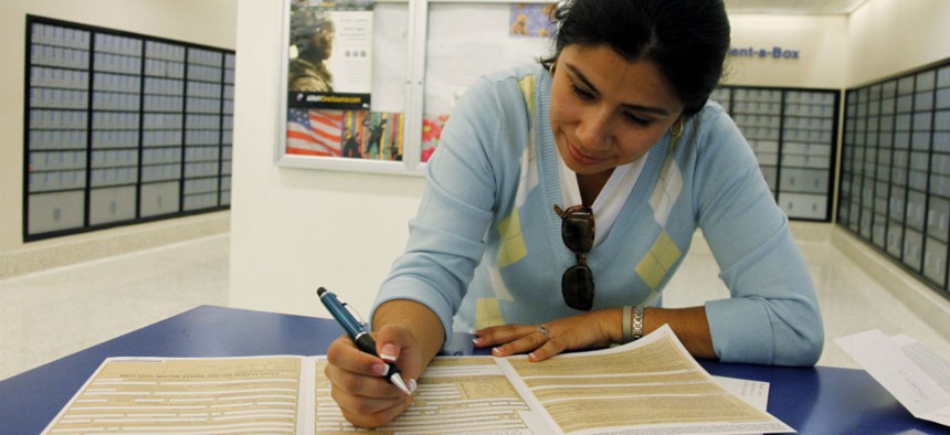 A passport applicant fills out forms in Los Angeles. Applications have spiked recently, requiring an increase in mandatory overtime at some State Department offices. 