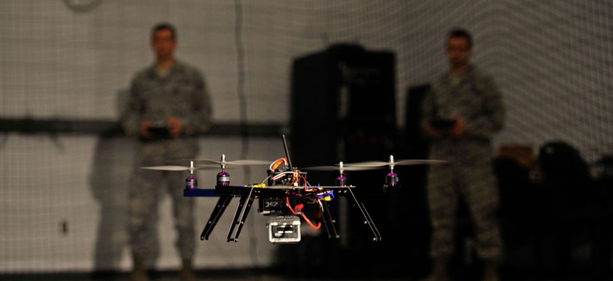 Air Force Capt. Wilfred Noel, deputy chief of the Air Force Research Lab, left, and 1st Lt. Jason Rathje, an advanced weapon design engineer with Air Force Research Lab weapons dynamics and control science branch, right, pilot quadrotor vehicles.