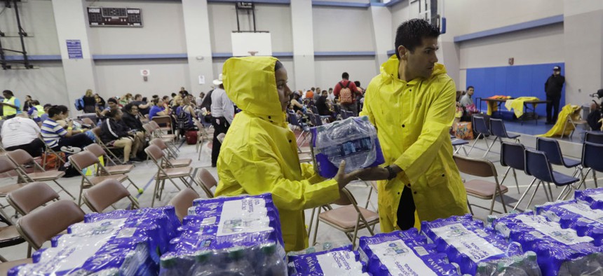 Officials deliver water to a holding area for residents waiting to be evacuated in Corpus Christi, Texas, ahead of Hurricane Harvey.