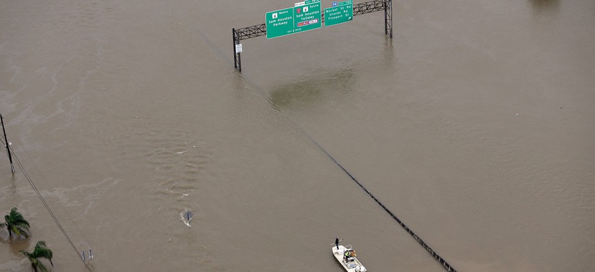 A boat travels along Interstate 10 as floodwaters from Tropical Storm Harvey cover a portion of the highway in August.