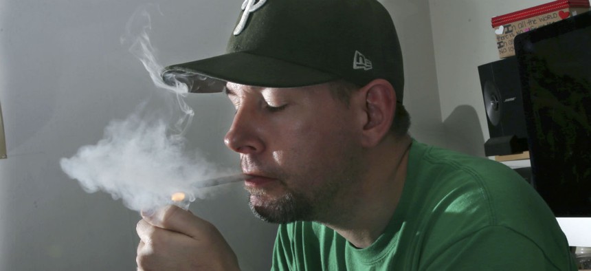 In this March 10, 2016, photo, former U.S. Marine, Mike Whiter lights a marijuana cigarette at his home in Philadelphia. Some veterans say marijuana helps them manage their anxiety, insomnia and nightmares.