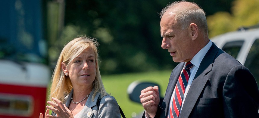 White House Chief of Staff John Kelly and Deputy Chief of Staff Kirstjen Nielsen speak together as they walk across the South Lawn of the White House in Washington. 