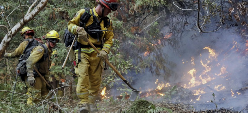 Fire crews build a containment line in mid-October as they battle a wildfire near Boulder Creek, Calif.