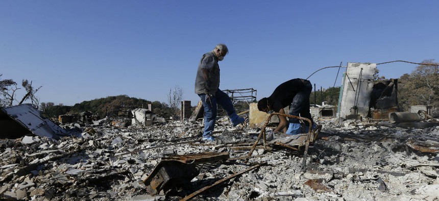 Friends search through the remains of a home destroyed in Santa Rosa, California, wildfires. 