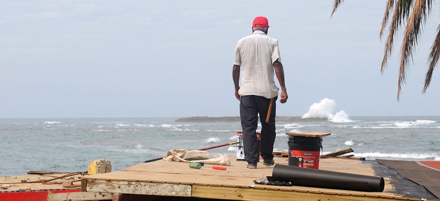 Manuel Dia repairs the roof of a restaurant in Carolina, Puerto Rico on Nov. 20.
