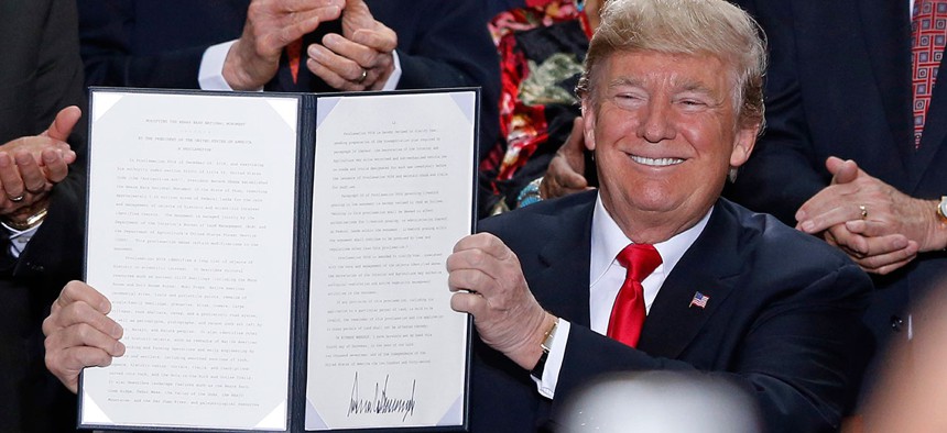 Donald Trump holds up a signed proclamation to shrink the size of Bears Ears and Grand Staircase Escalante national monuments at the Utah State Capitol on Monday.